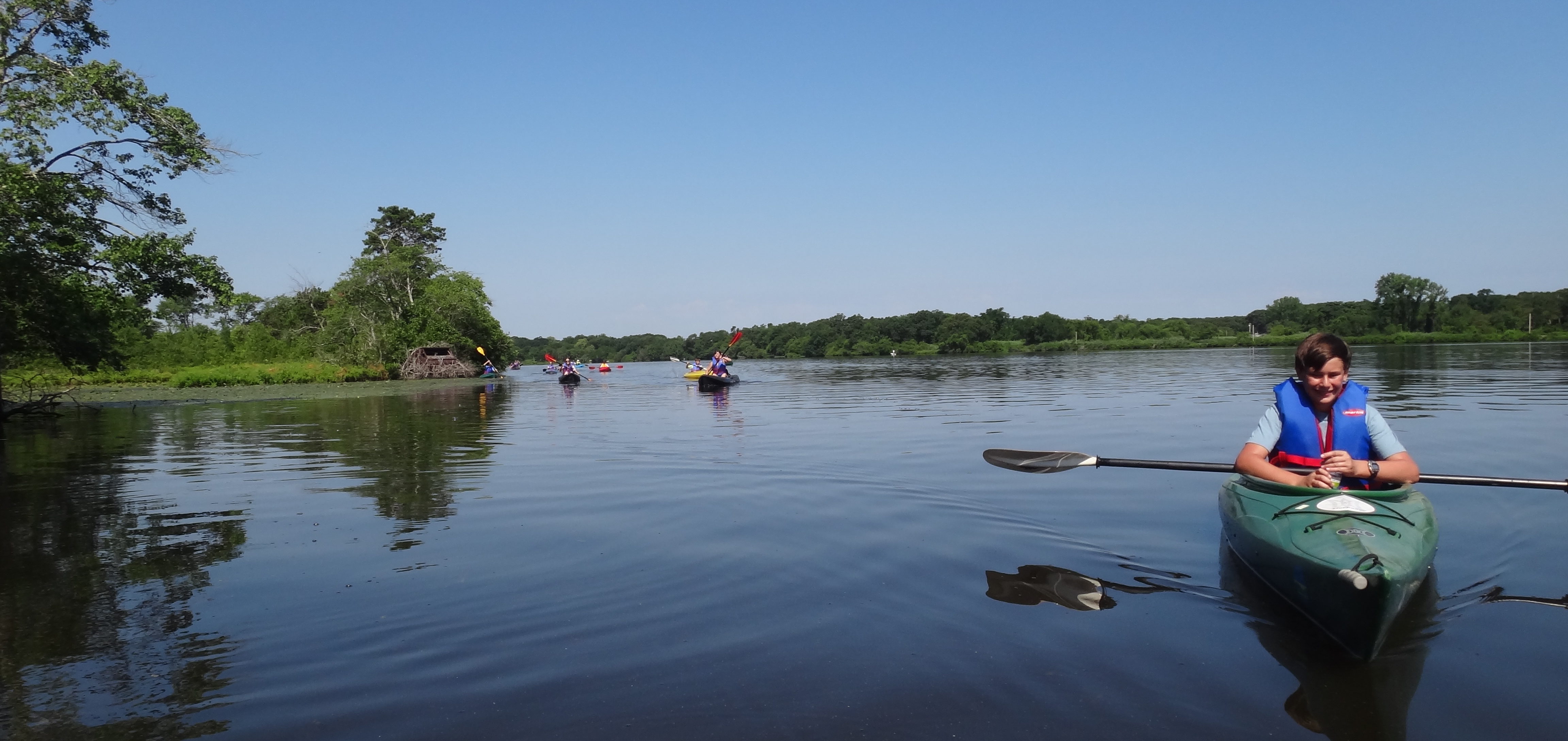 Kayakers paddling on the Peconic River.