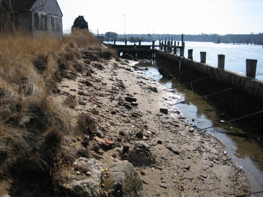 Erosion behind a bulkhead on the shore.