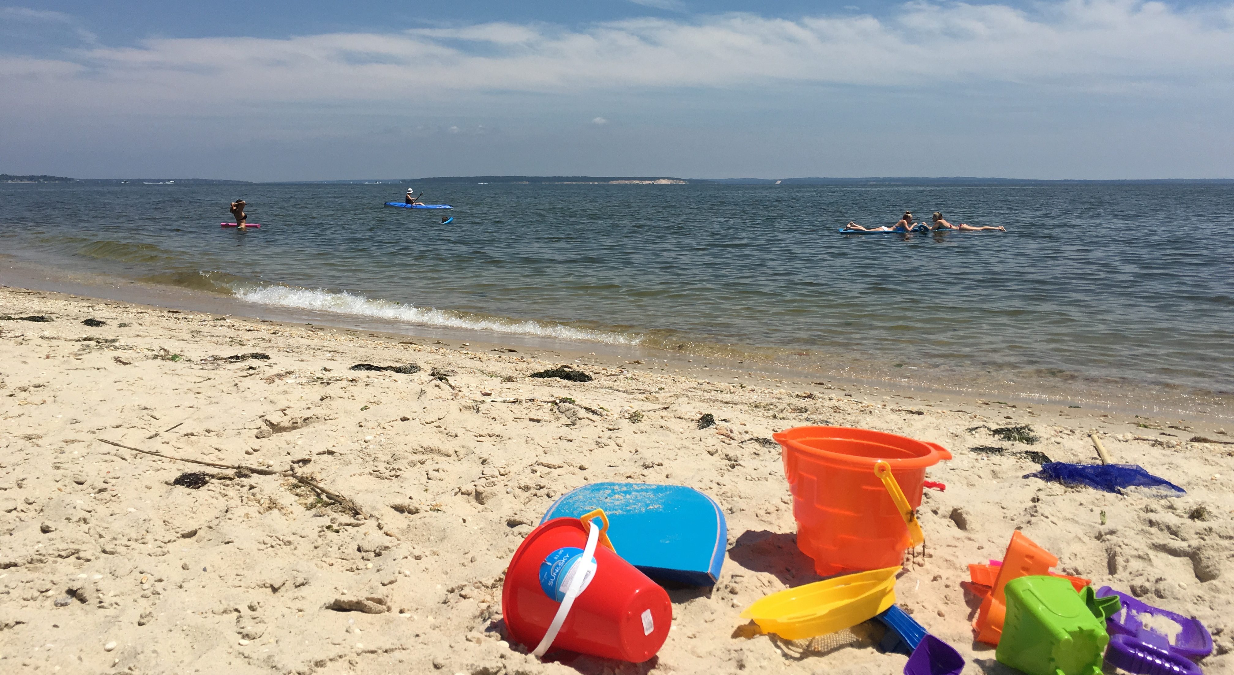 People enjoying the water and beach in the Peconic Estuary.